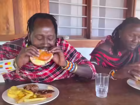 कई देशों में आज भी ऐसी जनजातियां हैं जो पुराने ढर्रे पर अपना जीवन व्यतीत करती हैं। न केवल भारत में, बल्कि अफ्रीका जैसे देशों में भी ये जनजातियाँ अभी भी शहरों या शहरीकरण से नहीं जुड़ी हैं। वे नहीं जानते कि रेस्तरां क्या हैं, शहर का खाना कैसा है और वहां के रीति-रिवाज क्या हैं। वे सिर्फ मानते हैं कि उनके तरीके सही हैं। अब जरा सोचिए कैसा नजारा होगा जब ऐसे लोग शहर में जाकर फास्ट फूड का लुत्फ उठाएंगे! ऐसा हाल ही में अफ्रीका के एक देश में देखने को मिला जहां के आदिवासी एक रेस्टोरेंट में बर्गर खाने गए (अफ्रीकी जनजाति पहली बार बर्गर खाने की कोशिश करती है)।  डेली स्टार न्यूज वेबसाइट के मुताबिक मासाई जनजाति केन्या और तंजानिया में रहती है। इस जाति के लोग कच्चा मांस, कच्चा दूध, शहद आदि खाते हैं और जानवरों का कच्चा खून भी पीते हैं। वे केवल ज़ेबू गायों का लहू पीते हैं। लेकिन अब इस जनजाति का एक कबीला हाल ही में अपना गांव छोड़कर शहर पहुंचा था जहां उन्होंने एक रेस्टोरेंट में बर्गर खाया।   आदिवासियों ने पहली बार बर्गर खाया एक यूट्यूब चैनल ने उनके अनुभव को रिकॉर्ड किया और दुनिया को उनके जंगल से शहर तक के सफर के बारे में बताया। इस वीडियो को मसाई बॉयज नाम के एक चैनल पर पोस्ट किया गया है। इस कबीले के मुखिया का नाम कनैया है। वह पूरे समूह के साथ बच गया। वहां उन्होंने एक फास्ट फूड रेस्तरां खोजने की कोशिश की और फिर बर्गर और चिप्स का लुत्फ उठाया। मसाई जनजाति की यह जनजाति बोली जाने वाली भाषा बोलने लगी है और अन्य जनजातियों की तुलना में बहुत विकसित हुई है। वीडियो में वह अंग्रेजी बोलते हुए भी नजर आ रहे हैं।  वीडियो वायरल हो रहा है वहां उन्हें वेजी बर्गर, चिकन बर्गर, चीज बर्गर और फिश बर्गर परोसे गए, लेकिन मसाई को मछली से नफरत है। अंत में, उसने बीफ पनीर बर्गर खाने का फैसला किया। वीडियो में दिख रहा है कि उन्हें बर्गर खाने में काफी दिक्कत हो रही है क्योंकि उन्हें नहीं पता कि इसे कैसे खाना चाहिए। कई लोगों ने वीडियो की तारीफ की है और कहा है कि ये लोग रियल लाइफ जी रहे हैं.